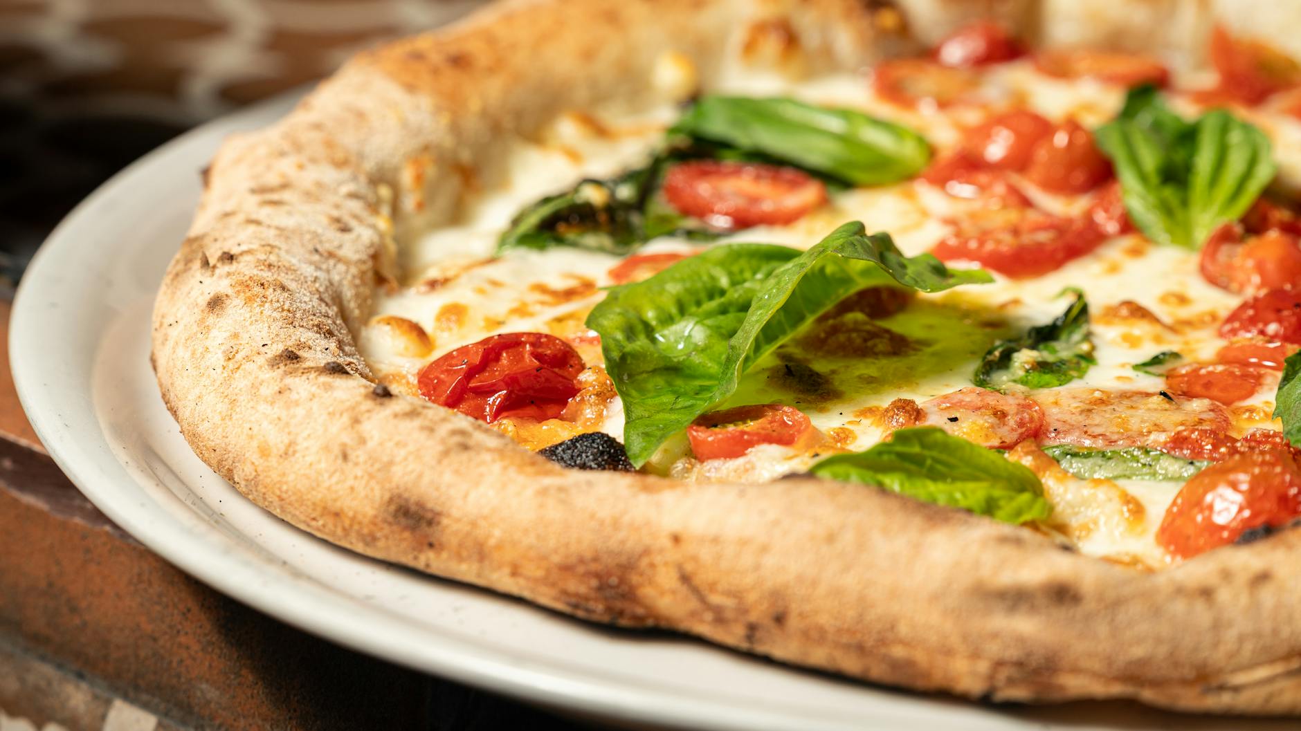 Pizza margherita z bazylią i pomidorkami w neapolitańskiej pizzerii