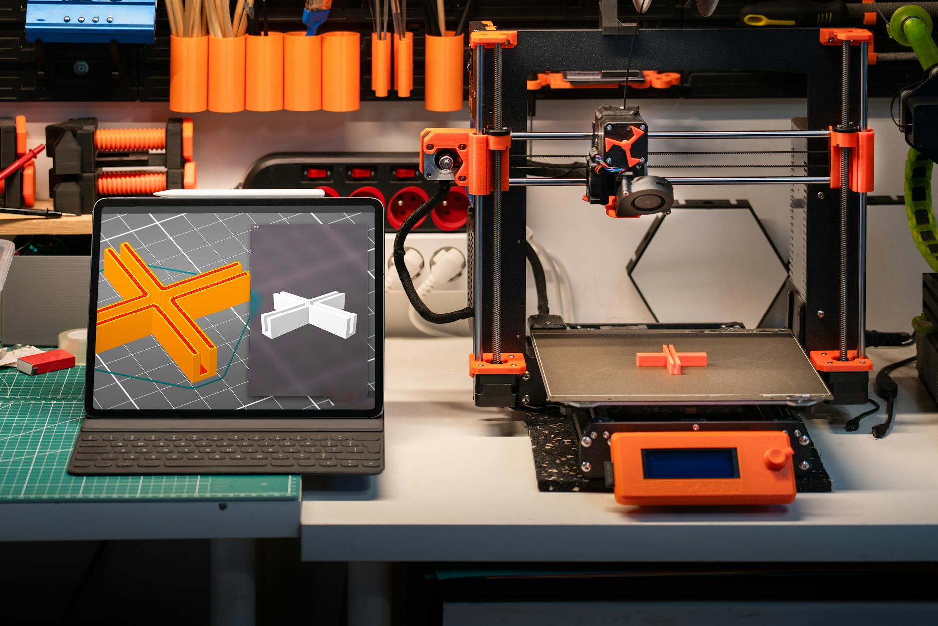 Biurko z drukarką 3D i komputerem wyświetlającym modele 3D
