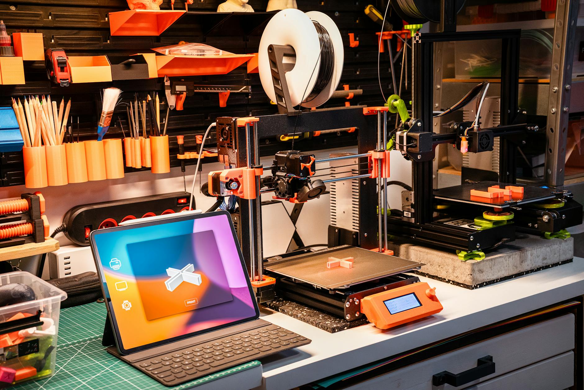 Stół roboczy z drukarkami 3D i tabletem w domowym warsztacie Stół roboczy z drukarkami 3D i tabletem w domowym warsztacie
