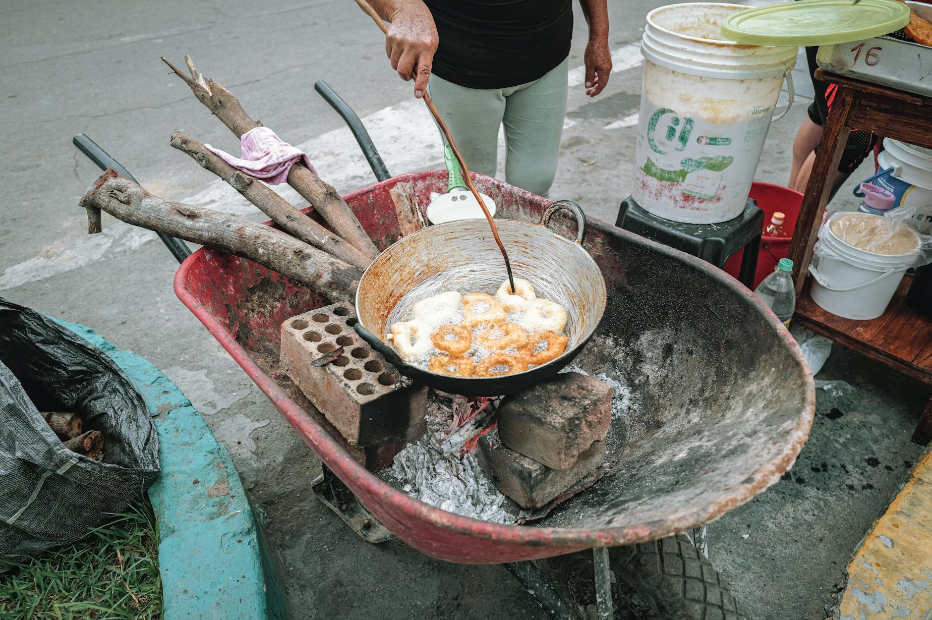 Uliczny sprzedawca smażący pączki na prowizorycznym straganie