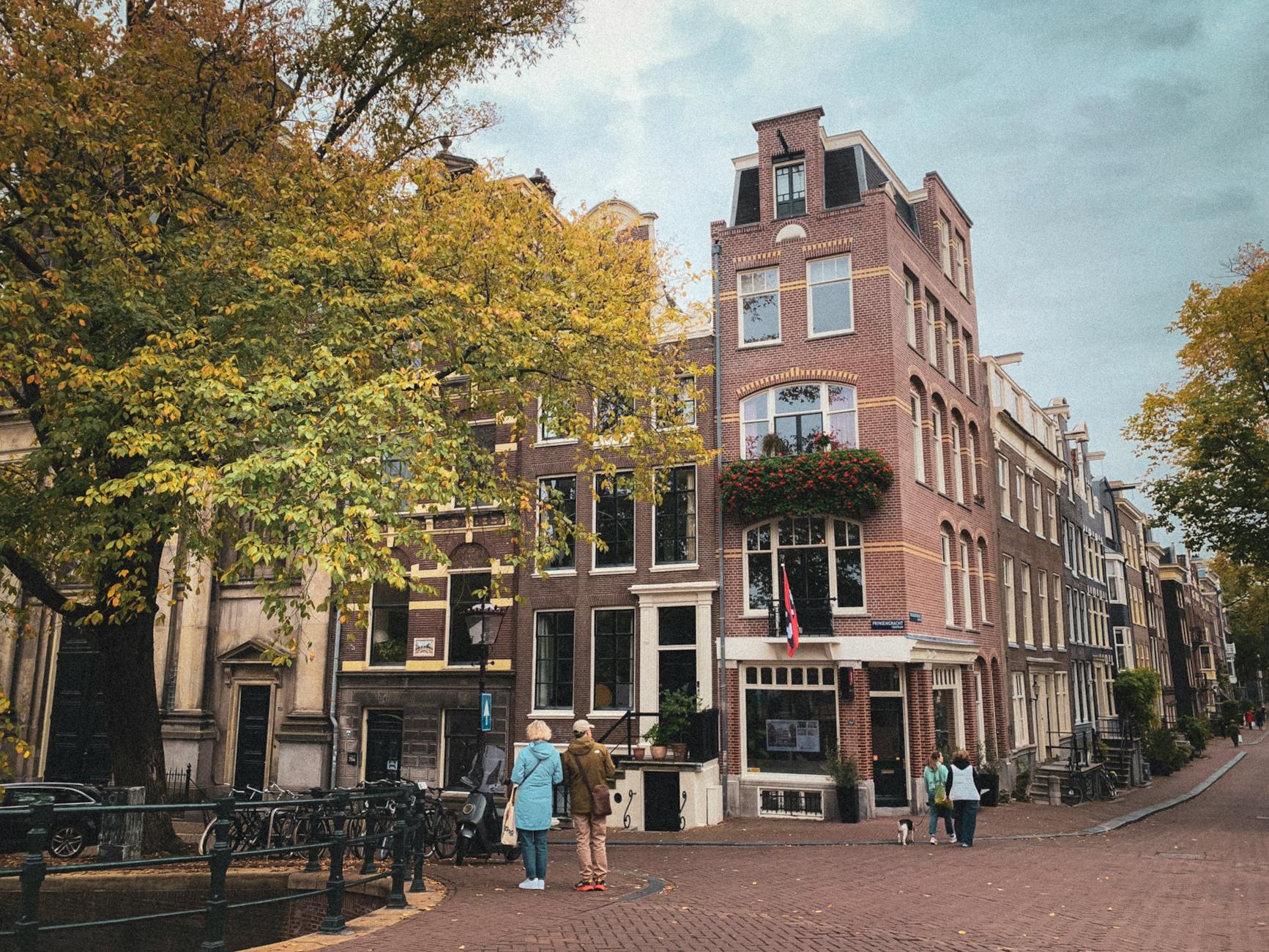Jesienna uliczka Amsterdamu z kamienicami nad kanałem