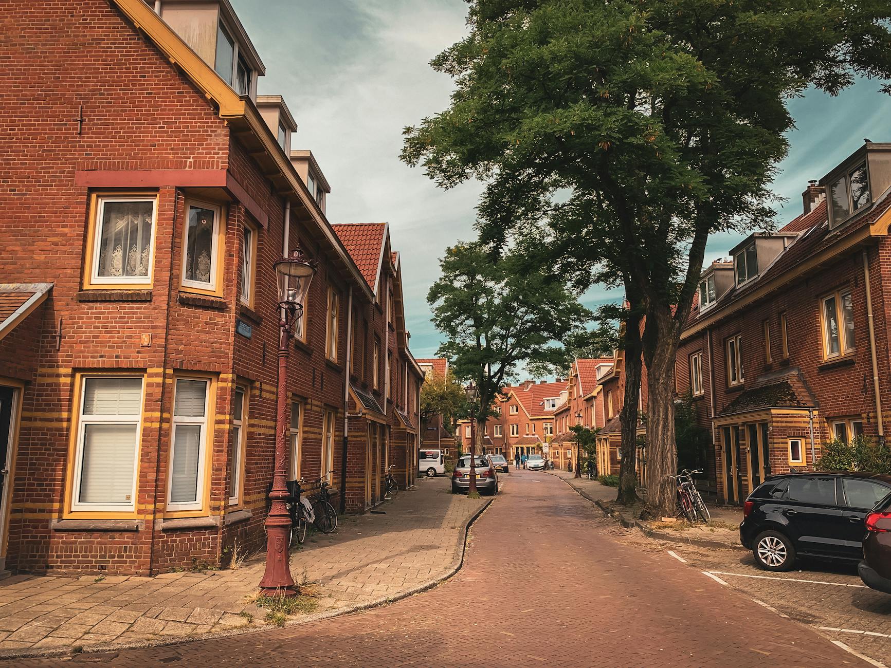 Spokojna ulica w Amsterdamie z tradycyjną holenderską zabudową i drzewami