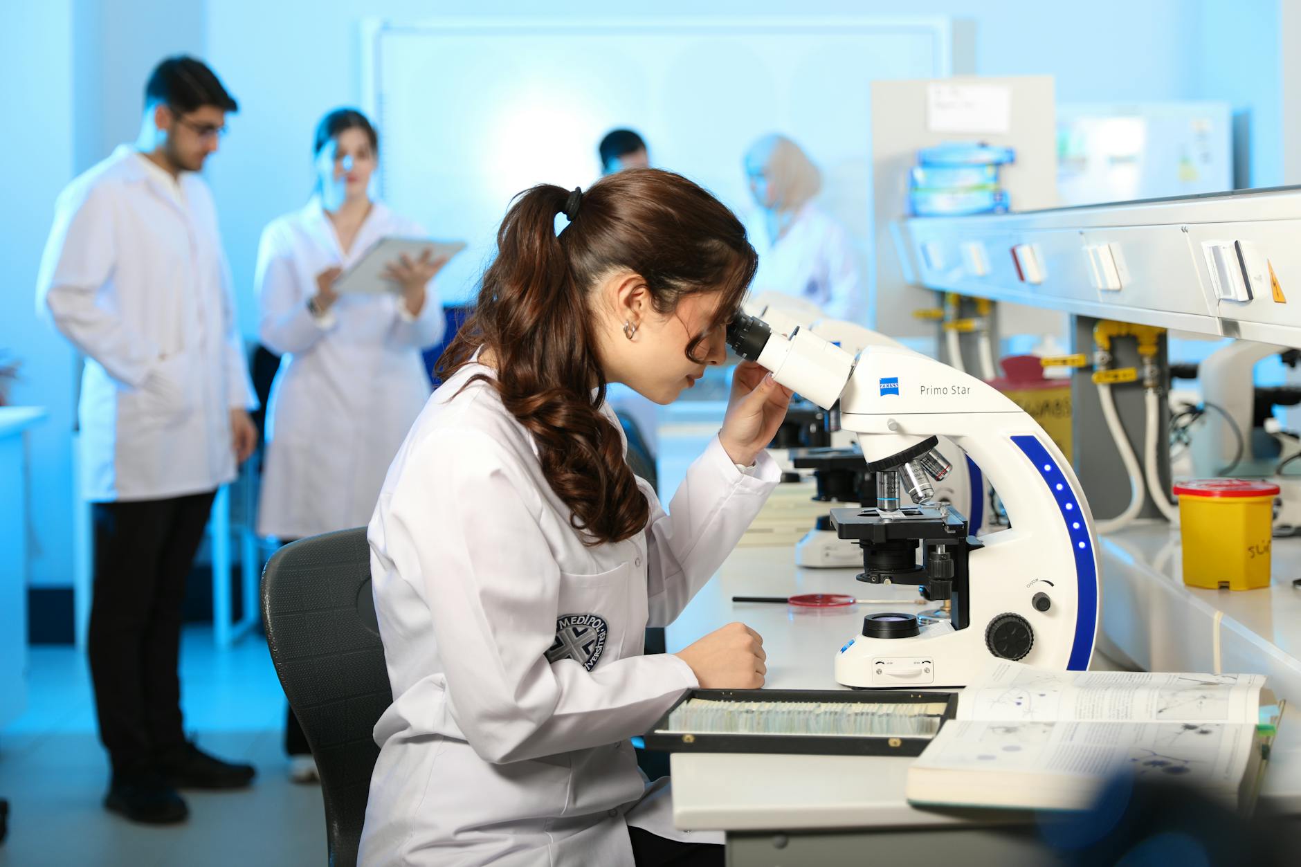 Studentka chemii ogląda próbki pod mikroskopem w laboratorium