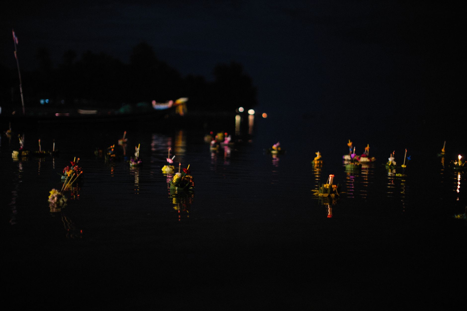 Podświetlone kratongi unoszące się nocą na wodzie podczas Loy Krathong Podświetlone kratongi unoszące się nocą na wodzie podczas Loy Krathong