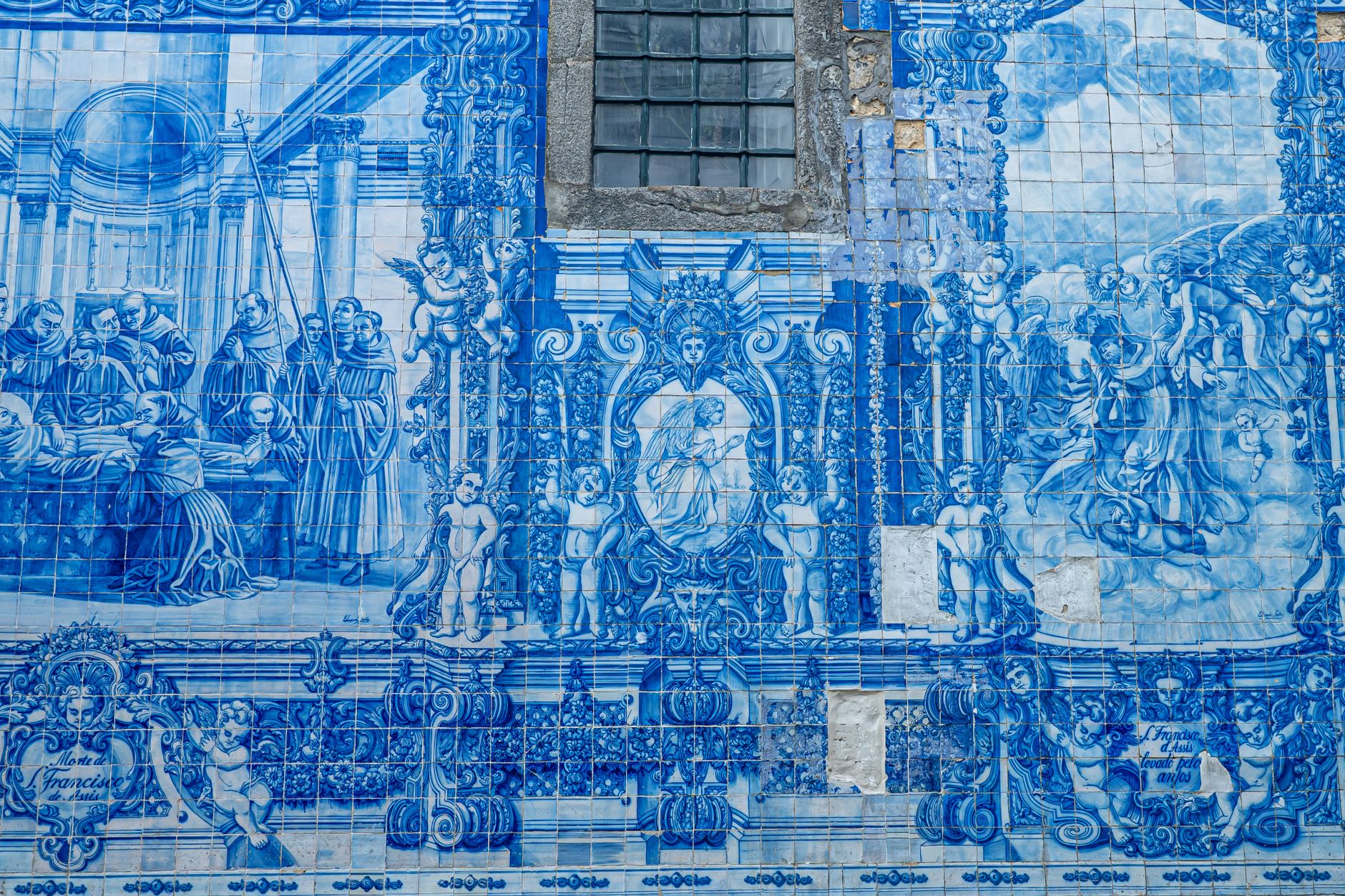 Niebiesko-biały mural azulejos z scenami historycznymi i religijnymi w Porto
