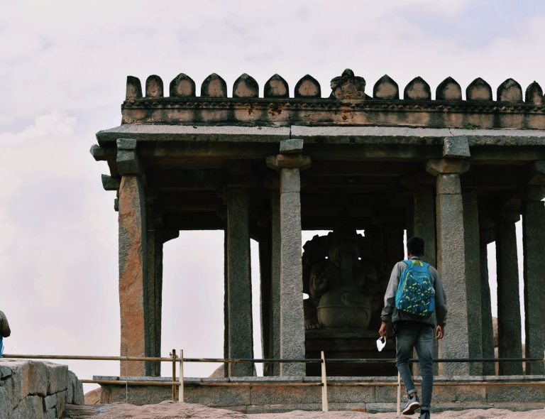 Mężczyzna z plecakiem przy świątyni Sasivekalu Ganesha w Hampi